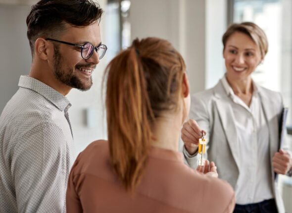 young-happy-couple-buying-new-home-receiving-key-from-their-real-estate-agent_637285-6085